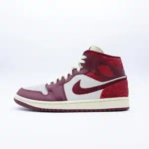 Tenis Air Jordan 1 Mid SE Tiki Leaf gamuza color hueso y piel rojo oscuro con bordado de hojas en talón y cuello, mediasuela crema.