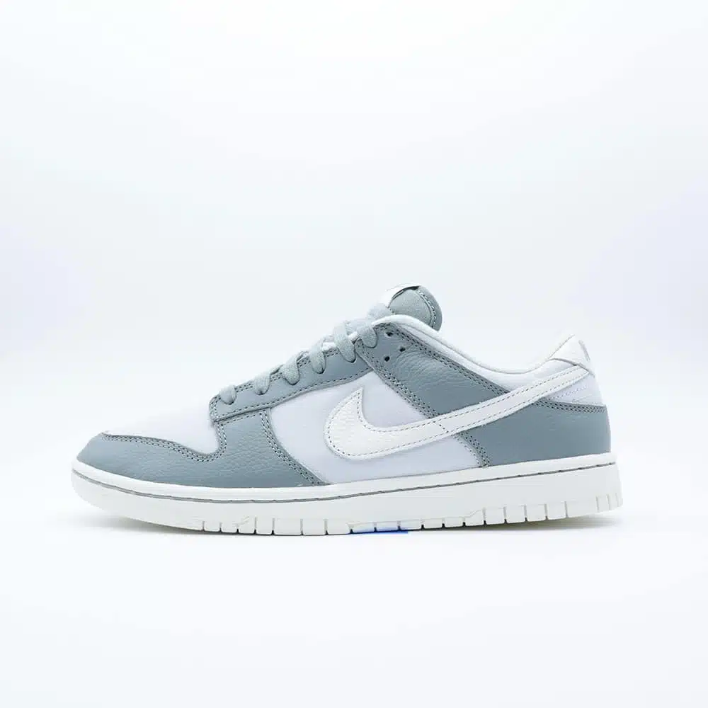 Tenis Nike Dunk Low Mica Green lona gris claro con paneles de piel verde menta en punta y talón, logo de Nike color hueso y mediasuela crema.