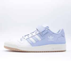 Tenis Adidas Forum Low "White Blue Dawn" para mujer. Silueta clásica de perfil bajo en piel color blanco y azul claro con correa de velcro y suela de goma.