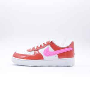 Tenis Nike Air Force 1 de mujer con acabado en charol rojo y detalles de corazones. Tenis con suela blanca y diseño especial de temporada.
