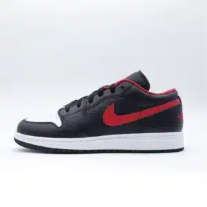 Tenis Air Jordan 1 Low White Toe piel negra con punta blanca, logo de Nike en rojo sobre los laterales y ribete rojo alrededor del collar del tenis.