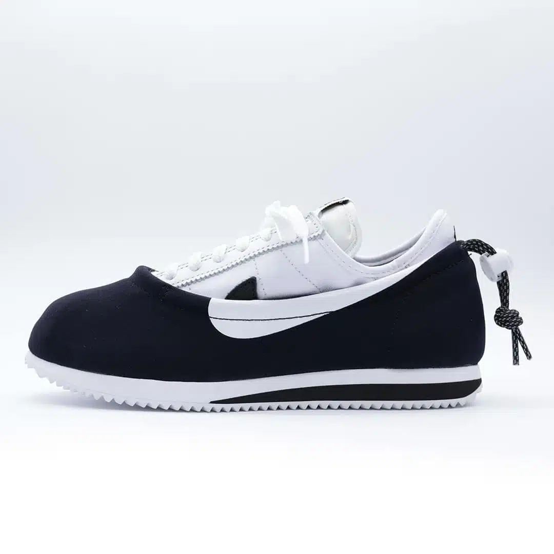 Tenis Nike Cortez CLOT CLOTEZ Yin Yang funda negra que se coloca sobre un Cortez blanco con logo de Nike negro, cordón con símbolo yin yang.