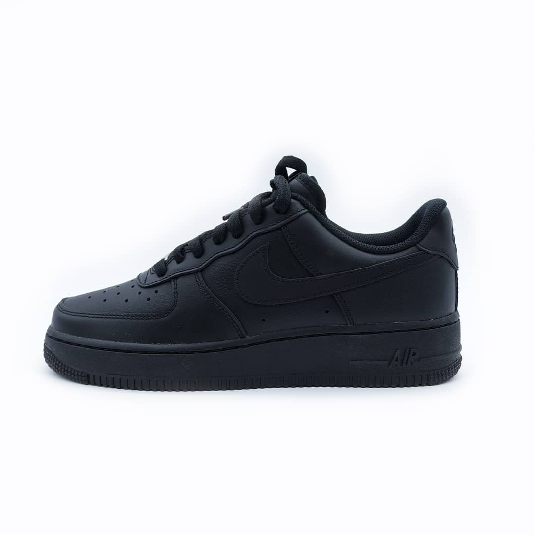 Tenis Nike Air Force 1 bajos negros para hombre. Tenis de piel en un solo tono con agujetas negras, suela negra y diseño clásico urbano resistente.