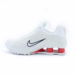 Tenis Nike Shox R4 de hombre en color blanco. Tenis con columnas de amortiguación rojas en la suela, exterior de piel sintética y detalles bordados.