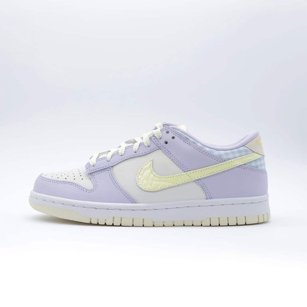 Tenis Nike Dunk Low para mujer, color lila y crema, de corte bajo. Diseño detallado con texturas y estampado de cuadros en el talón.