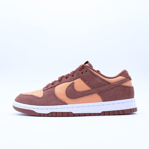 Tenis Nike Dunk Low para hombre y mujer, en combinación de tonos café y ámbar. Diseño fabricado en cuero y gamuza con suela de goma.