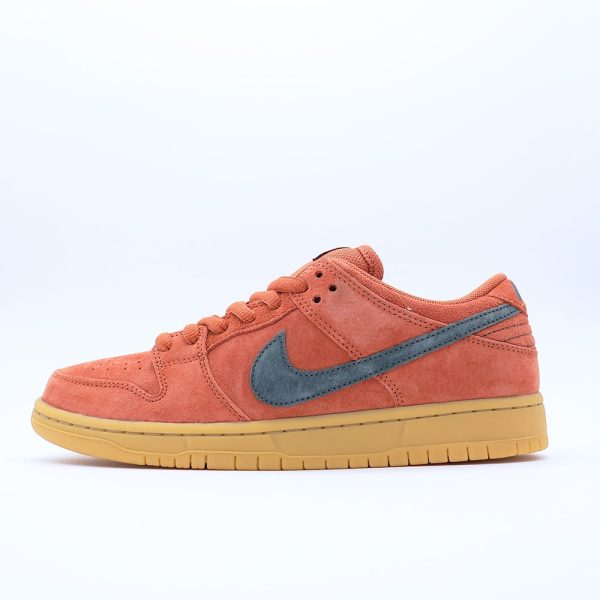 Tenis Nike SB Dunk Low para hombre y mujer, color naranja quemado, corte bajo. Diseño en gamuza premium con suela de goma, ideal para skate y uso urbano.