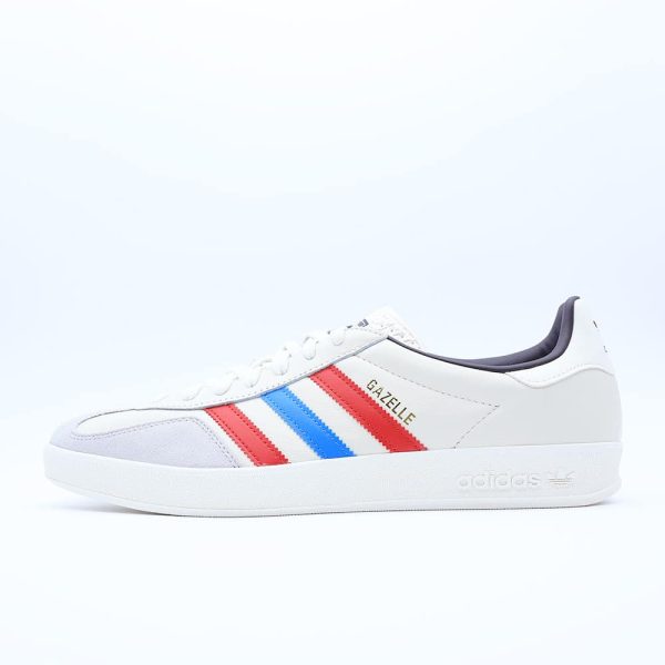 Tenis Adidas Gazelle para hombre. Silueta clásica de perfil bajo en piel blanca con puntera de gamuza gris y las tres franjas en color rojo y azul.